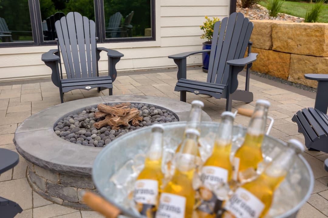 Adirondack chairs around a fire pit with a bucket of Corona beers for outdoor entertaining.