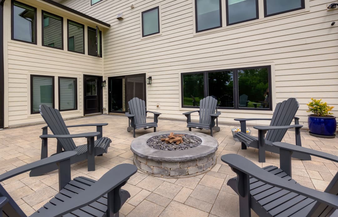 Cozy outdoor patio with fire pit and Adirondack chairs for relaxing gatherings.
