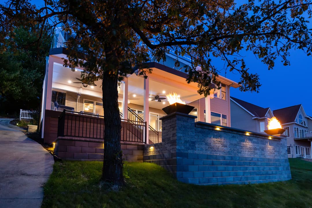 Modern house exterior at twilight with lit features and landscaped yard.