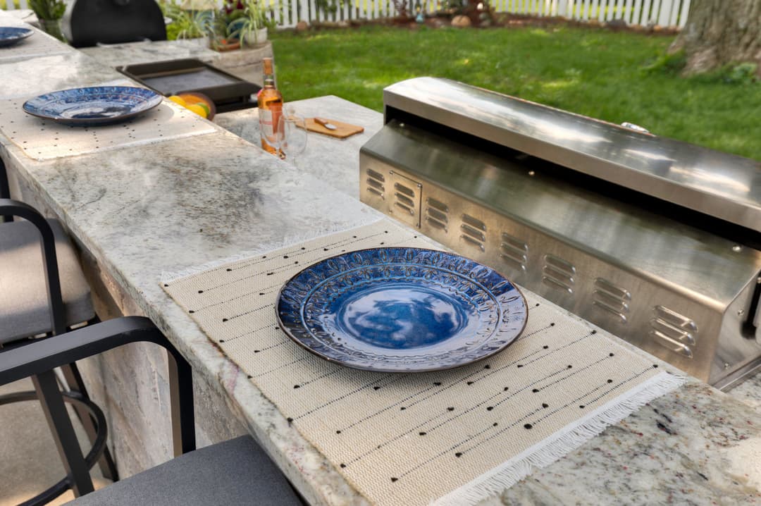 Elegant blue plate on a stylish outdoor kitchen countertop set for al fresco dining.
