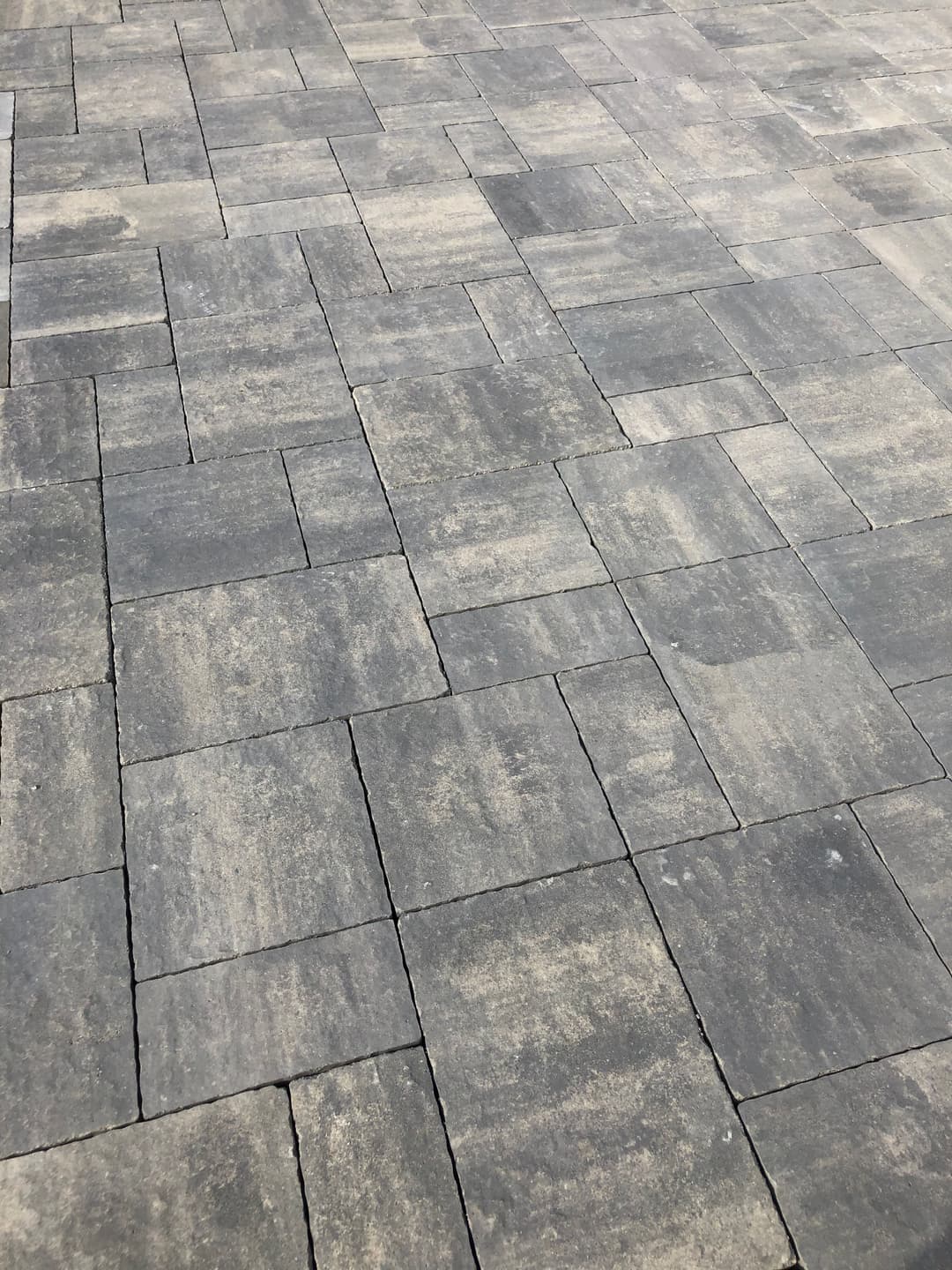 Gray interlocking pavers arranged in a modern, textured pattern for paving surfaces.
