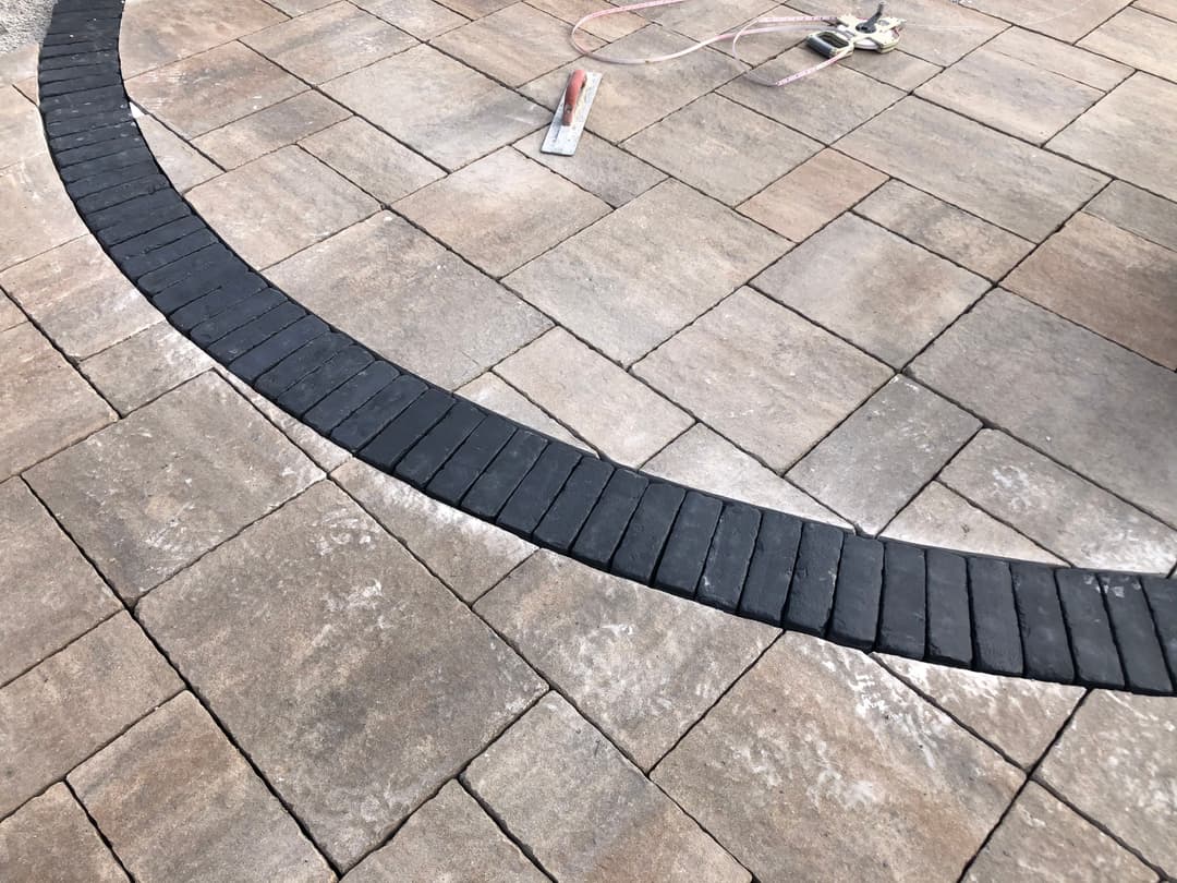 Paved patio with interlocking stones and a contrasting black border.