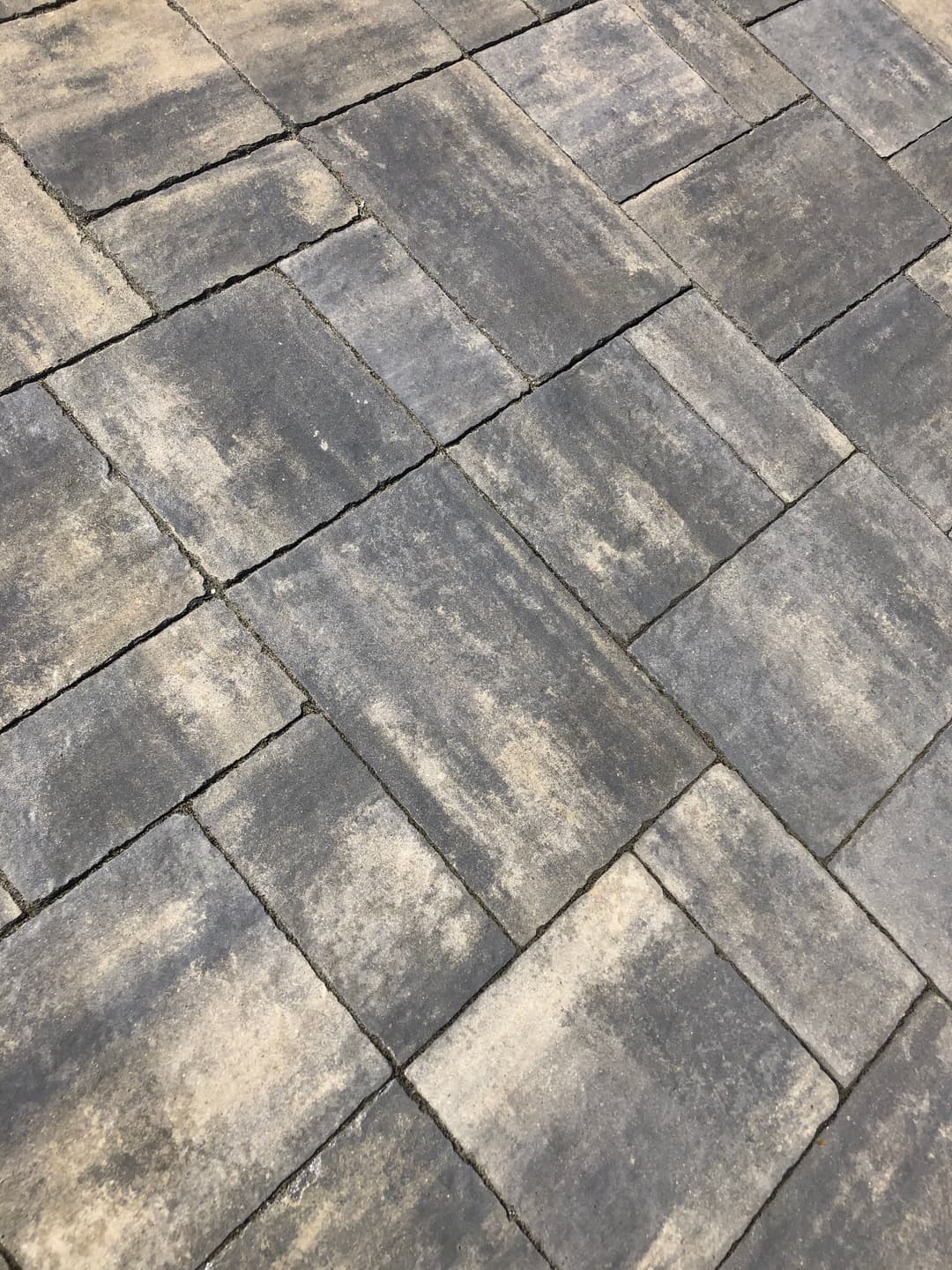 Textured gray paving stones arranged in a geometric pattern for outdoor flooring.