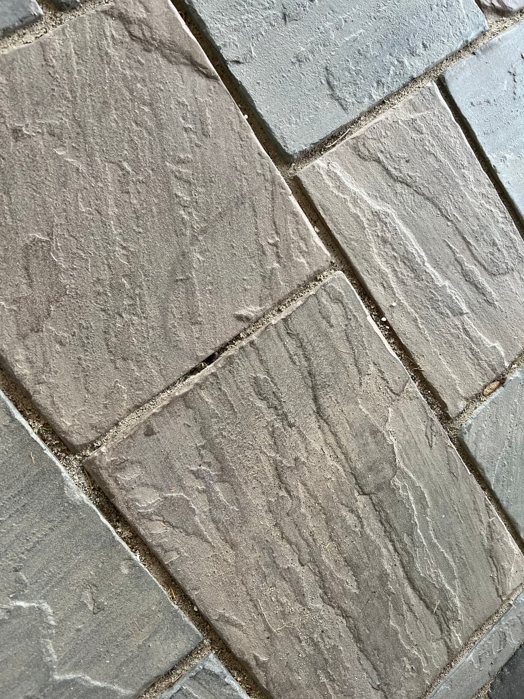 Textured stone tiles in a diagonal pattern showcasing various shades of gray.