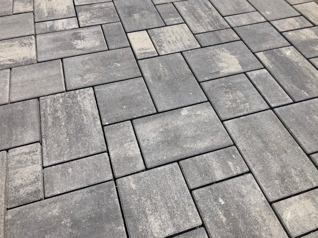 Textured gray paving stones arranged in a modern pattern for landscaping or outdoor spaces.